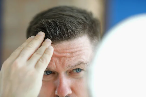 Człowiek robi żel do włosów stylizacji przed lustrem. — Zdjęcie stockowe
