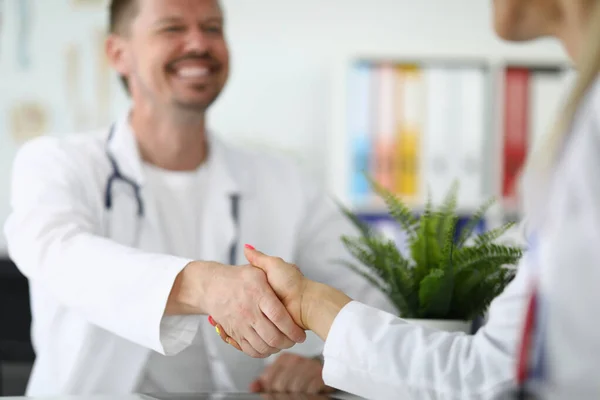 Apretón de manos entre dos médicos con batas blancas —  Fotos de Stock
