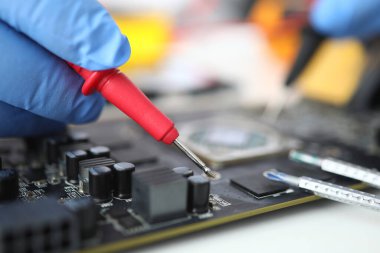 Eldiven ustası mikro devre üzerinde sonda tutuyor.