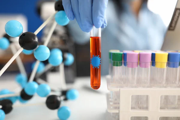 Hand in Hand hält Reagenzglas mit Flüssigkeit auf dem Hintergrund von Molekülen und Reagenzgläsern — Stockfoto