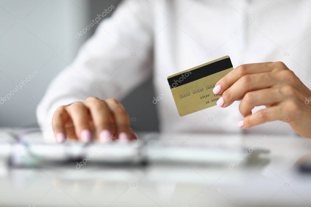 Silhouettes of woman in whose hands credit bank card.