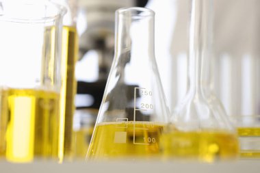 Şişeler ve test tüpleri sarı sıvı içerir.