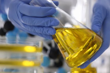 Eldivenli eller altın sıvıyla şişeyi tutsun..