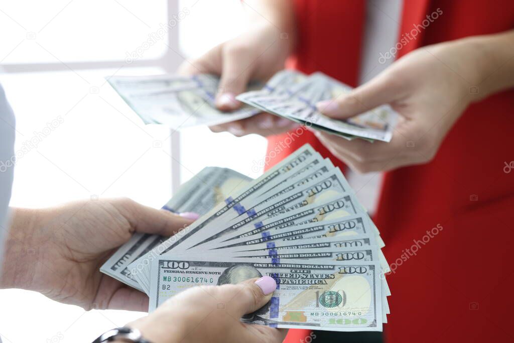 One hundred USA dollar bills are being counted in their hands