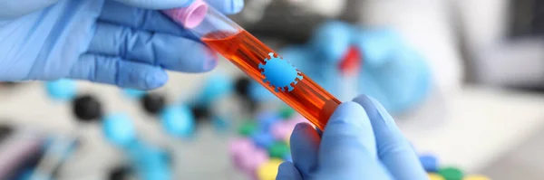 Handen in rubberen handschoenen houden reageerbuis met bloed geïnfecteerd met coronavirus in biologisch laboratorium close-up — Stockfoto