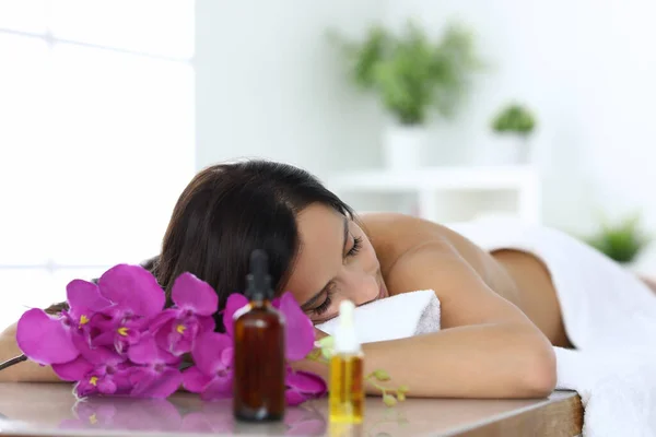 Femme se trouve avec les yeux fermés sur la table de massage dans le centre de spa — Photo