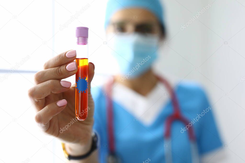 Doctor holds in his hands a test tube with liquid with bacterium sticker