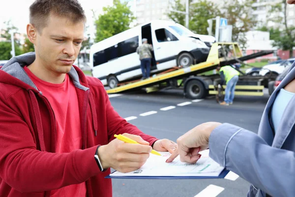 Försäkringsagent ger föraren att underteckna dokument efter olyckan. — Stockfoto