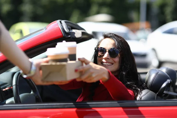 Caja de café se entrega a la mujer sonriente en el coche. — Foto de Stock