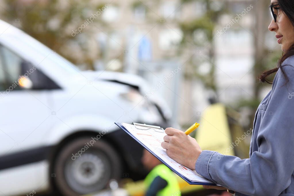 An agent fills out paperwork after car accident.