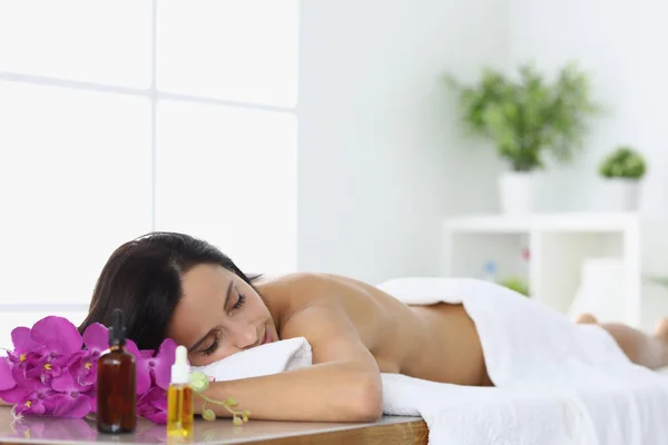 Ontspannen vrouw ligt in spa centrum op massagetafel. — Stockfoto