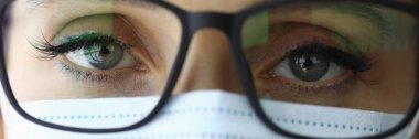 Koruyucu tıbbi maske ve gözlüklü bir doktorun portresi..