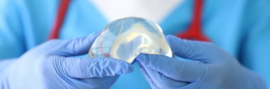 Doktor silikon implantı eldivenlere yakın çekim yapar.
