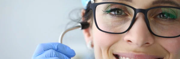 Portrait de médecin souriant avec des lunettes avec sa main tenant arc de stéthoscope — Photo