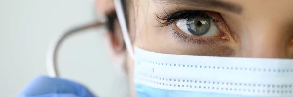 Portrait of doctor in protective medical mask with determined look