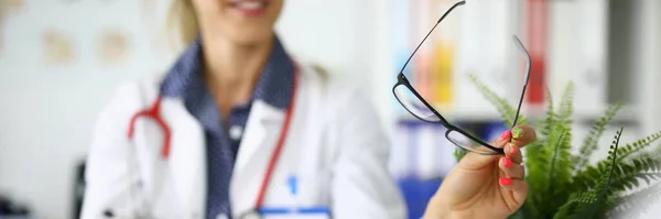 Ärzte mit Tablet und Brille in der Hand sitzen bei Besprechung in der Klinik am Tisch — Stockfoto