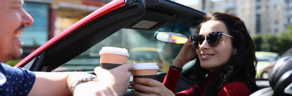 Mujer en gafas de sol en cabriolet rojo bebe café con retrato de hombre — Foto de Stock