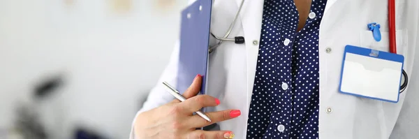 Arzt in weißem Mantel mit Klemmbrett-Stethoskop und Stift in der Hand — Stockfoto