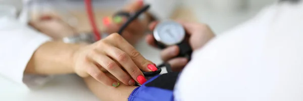 Γιατροί γυναικείο χέρι μετρά την αρτηριακή πίεση στον ασθενή. — Φωτογραφία Αρχείου