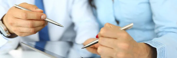 Empresario y mujer de negocios están sosteniendo bolígrafos y tabletas en la mesa de trabajo. — Foto de Stock