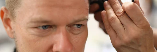 Retrato del hombre cuyos cortes de estilista con cortador de pelo. — Foto de Stock