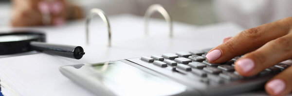 Женщины руки на калькулятор рядом с лупой и документов