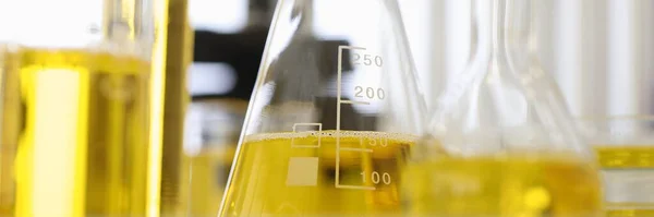 Baňky a zkumavky obsahují žlutou tekutinu — Stock fotografie