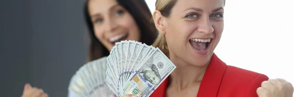 Two happy women are holding fan of one hundred dollar bills — Stock Photo, Image