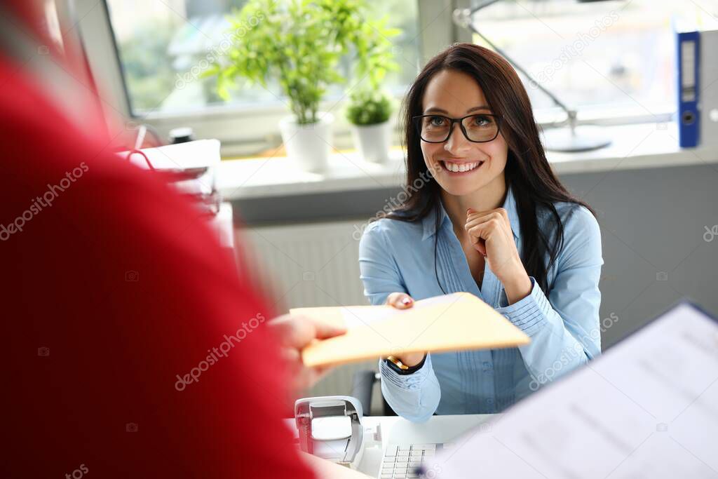 Young woman receiving yellow envelope from courier