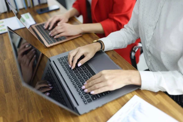 Женщины, печатающие на клавиатуре ноутбука в офисе крупным планом — стоковое фото