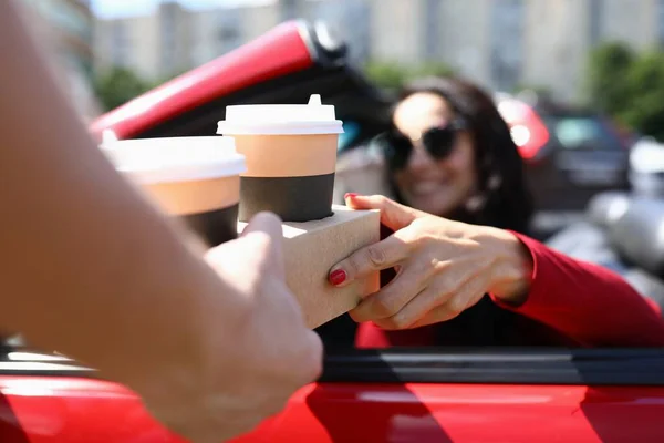 Servitör serverar kaffe till kvinna i bil närbild — Stockfoto