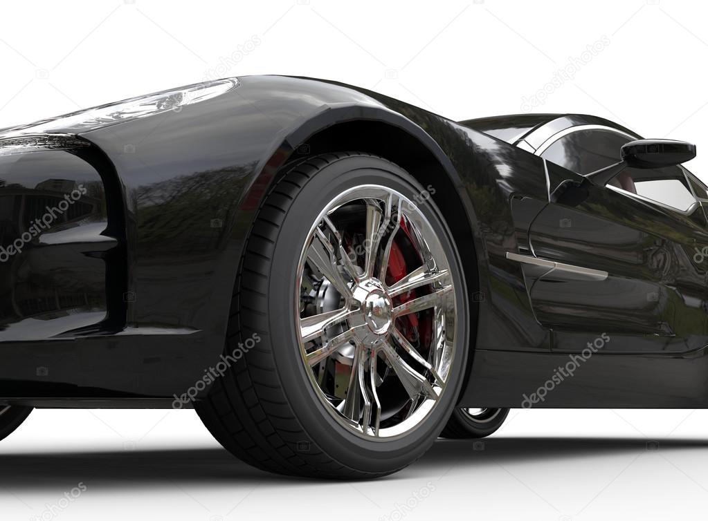 Black luxury sports car on white background - wheel close up.