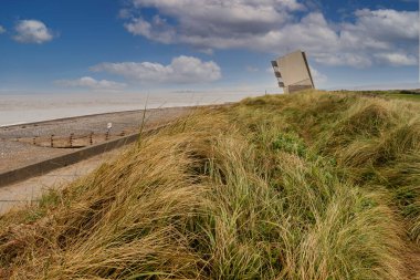 Rossall Sahili, Fleetwood, Lancashire, İngiltere. Rossall Point 'in dış güvertesindeki dört katlı bina Rossall Sahil Güvenlik Kulesi. Kıyı patikası boyunca bir yol işareti..