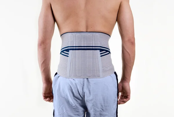Uomo senza camicia che indossa il tutore per sostenere la parte bassa della schiena — Foto Stock