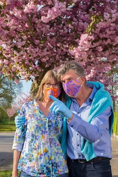 Couple Âgé Affectueux Portant Des Masques Des Gants Colorés Pendant Photo De Stock