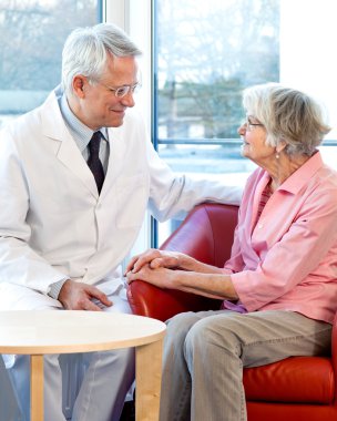 Physician consulting with an elderly woman.  clipart