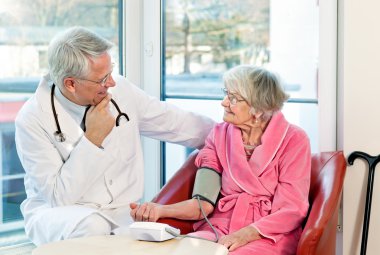 Yaşlı kadının tansiyon alarak doktor.