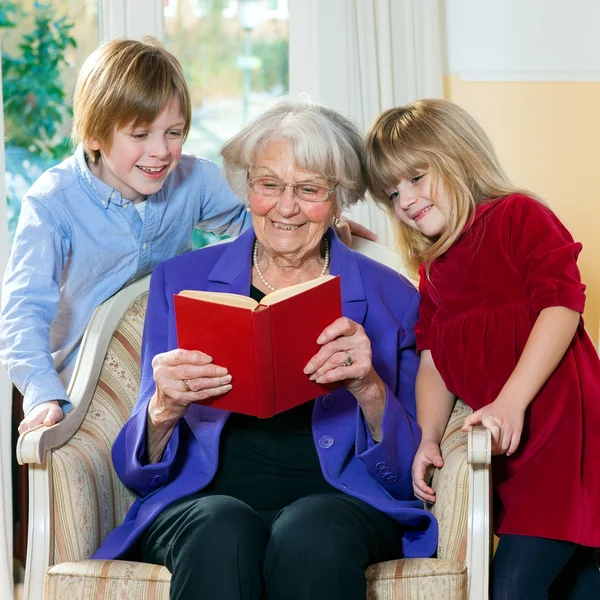 Grootmoeder leesboek aan kleinkinderen. — Stockfoto