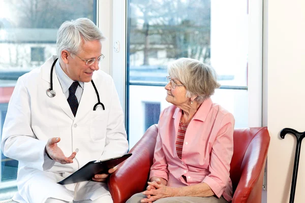 Médico varón en consulta con un paciente mayor . — Foto de Stock