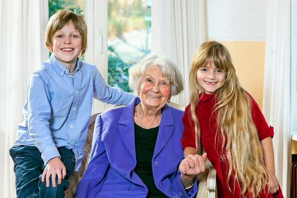 Grandmother posing with her two grandchildren. 