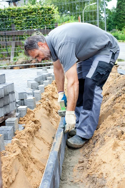 Trabajador pone losas de piedra — Foto de Stock