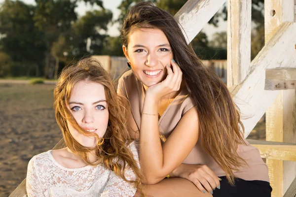 Kvinnliga vänner sitter på trätrappor — Stockfoto