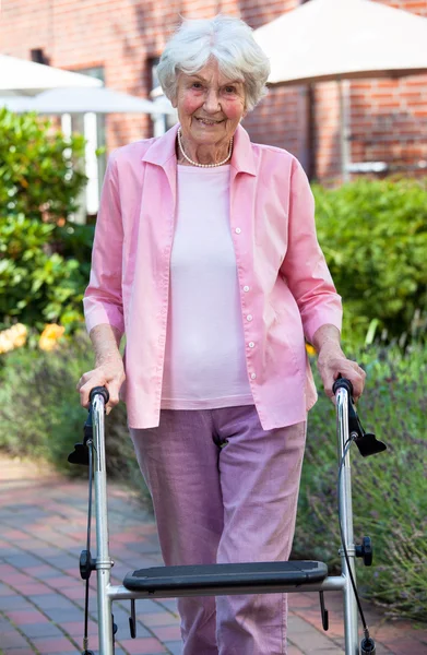 Oudere dame met behulp van walker — Stockfoto