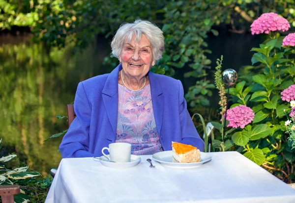 Senior vrouw zitten in de tuin — Stockfoto