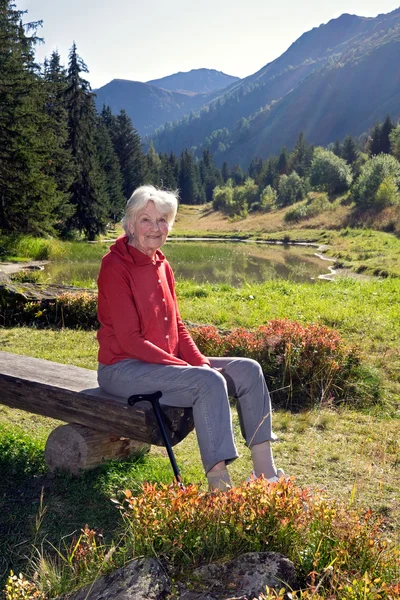 Senior mulher sentada no banco — Fotografia de Stock