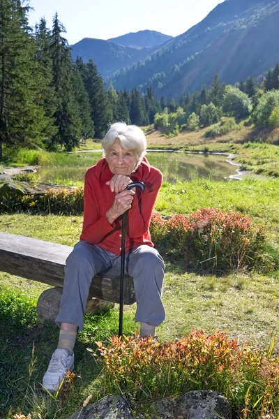 Femme âgée assise sur un banc Photos De Stock Libres De Droits