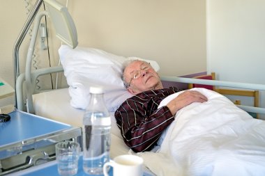 man recuperating in a hospital lying
