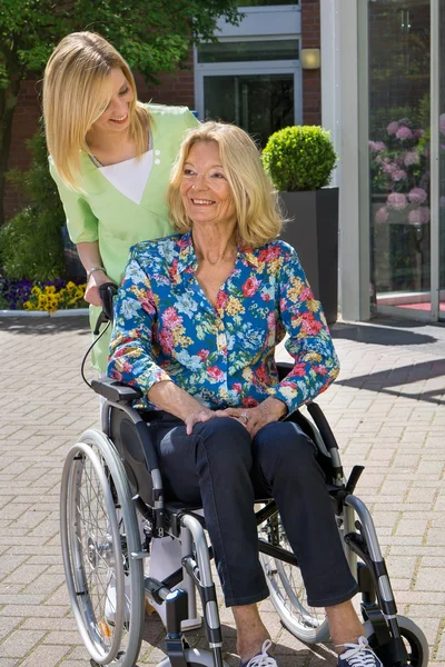 Blond Nurse Standing Behind Senior Woman — Stockfoto