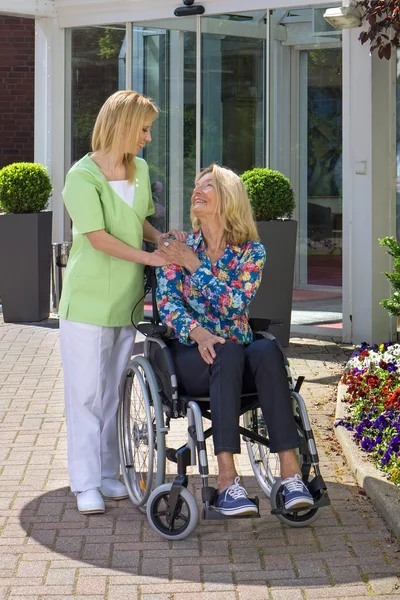 Krankenschwester steht hinter Seniorin — Stockfoto