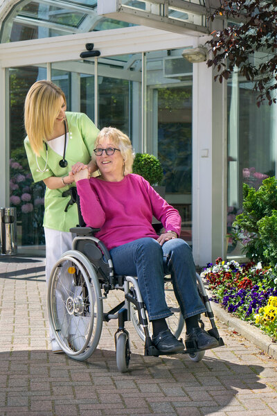 Nurse Standing Behind Senior Woman